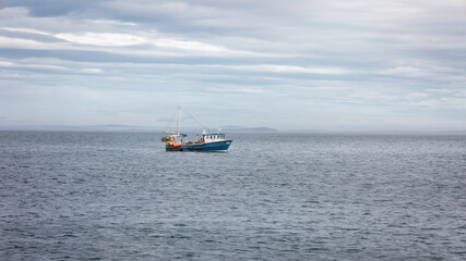 Obraz premium A fishing boat in the North Sea off the northern Scottish coast near the famous John o' Groats in the historic county of Caithness