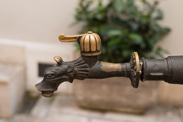 Old antique faucet in medieval town