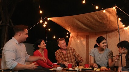 Family gather for holiday celebration in garden. Family member gather have dinner. Outdoor camping...