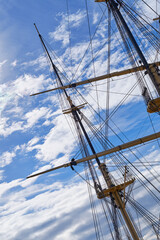 Obraz premium Blue sky, rope and travel with mast of ship outdoor in nature from below for Danish heritage. Adventure, engineering and history with flagpole on sail boat for journey, holiday or vacation at sea