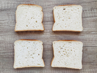 Square pieces of white toast bread on a wooden background