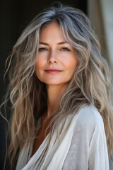 Fototapeta premium A woman with long gray hair is posing for a picture