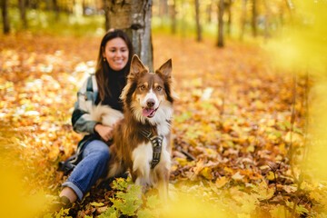 Loving woman with her shepherd Australian on fall season