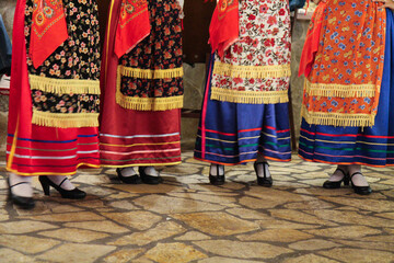 Cultural Dance Performance by Greek Women in Traditional Red and Blue Folk Dresses, Entertaining Guests at a Restaurant