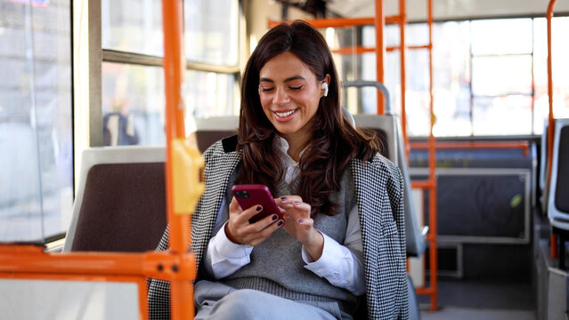 Beautiful young woman engaged in a phone during her bus ride