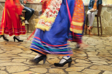 Cultural Dance Performance by Greek Women in Traditional Red and Blue Folk Dresses, Entertaining Guests at a Restaurant