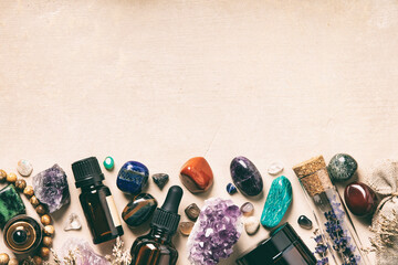 Assorted Crystals, Essential Oils, and Dried Herbs on Beige Background