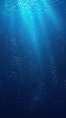 Obraz premium A serene underwater scene with rays of sunlight filtering through the deep blue water, creating a tranquil ambiance.