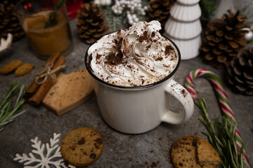 Cozy background of mug with hot chocolate and whipped cream on top Cookies, cinnamon sticks 
