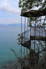 Rustic Metal Gazebo with Rusty Spiral Stairs Leading Toward the Sea, Surrounded by Greek Island Landscape