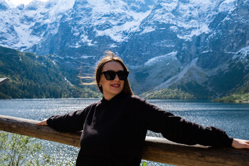 Young woman enjoying nature in Morskie Oko Snowy Mountain Hut in Polish Tatry mountains Zakopane Poland. Naturecore aesthetic beautiful green hills. Mental and physical wellbeing Travel outdoors