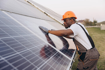 African American Male Engineer Inspecting Solar Panels On A Sunny Day Outdoors