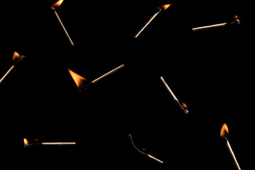 Lit falling match on a black background.