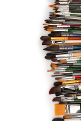 Mix of paint brushes in a row isolated on a white background.