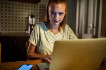 Woman working late at night on laptop at home
