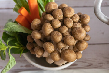 Fresh and vibrant mushrooms arranged beautifully with vegetables in a bowl, showcasing nature's bounty.