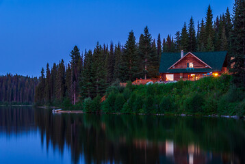 Fototapeta premium Luxury cabin with nice Summer lake view and forest landscape in Vancouver, Canada, North America. Night time on June 2024.