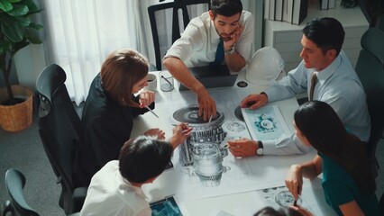 Naklejka premium Top view of professional engineer showing and talking about turbine engine design. Aerial view of skilled designer or technician group explain about electronic generator construction. Alimentation.