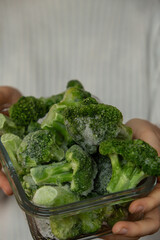 Unrecognizable woman showing into camera frozen food broccoli florets homemade. Harvesting concept. Stocking up vegetables for winter storage Healthy food, Cooking ingredients