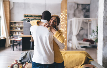 Happy couple embraces after receiving keys to their new home, symbolizing a joyful milestone in real estate. Dark-skinned man and his partner celebrate their new beginning in cozy, modern living space