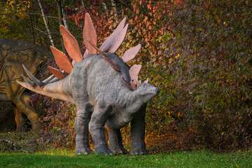 Large stegosaurus figurine by the forest.
