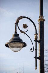 A street light with a bulb hanging from a metal pole