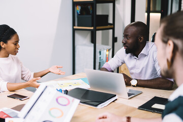 Group of young multiracial workers brainstorming at well lit office