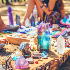 Colorful crystals and gemstones displayed outdoors, creating a spiritual and bohemian atmosphere in natural surroundings.