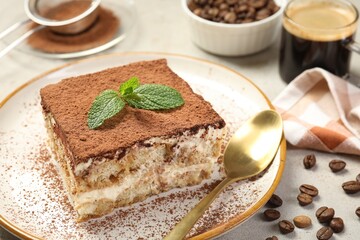 Piece of tasty tiramisu on beige table, closeup