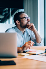 Thinking man making notes in office