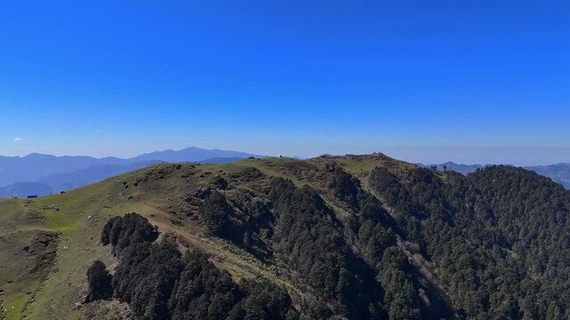 A stunning mountain valley in Jibhi, Himachal Pradesh, surrounded by lush, dense forests