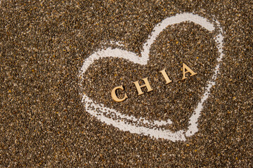 Heart made of chia seeds with word CHIA inside background. Healthy superfood rich in Omega 3 fatty acids. Dry healthy natural ingredient. Vegetarian food favorite dietary products