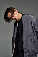 A trendy young man showcases his autumn style with confidence in a sleek, contemporary ensemble.