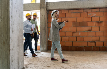 	
A female architect and construction managers work together on-site, discussing blueprints and coordinating to bring their project to life.	
