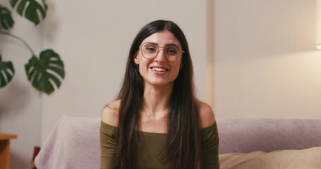 Brunette woman waves hand expressing warm greeting to interlocutor