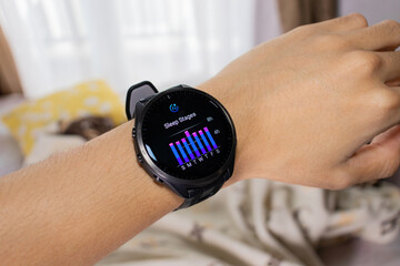 Smartwatch is being used as a sleep tracker with bed in the background. After edits.