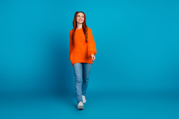 Full size photo of pretty young girl walk look empty space wear trendy knitted orange outfit...