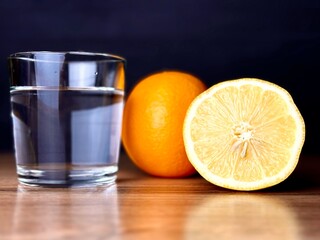 glass next to orange and lemon close-up