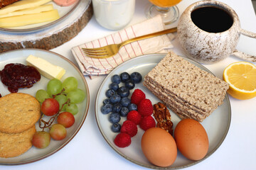 Assortment of various breakfast foods and drinks on the white table. Selective focus.