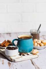 blue mug with hot chocolate and cookies on white table, vertical