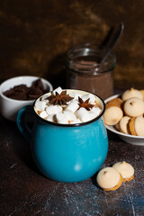 mug of spicy hot chocolate with marshmallows on dark background, vertical closeup