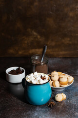 mug of spicy hot chocolate with marshmallows on dark background, vertical