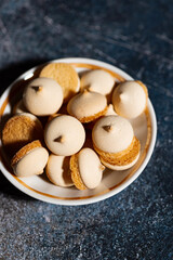 plate with amaretti cookies on dark background, vertical