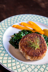 Crispy fish cake on bed of greens