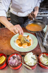 Chef plating a scallop plate
