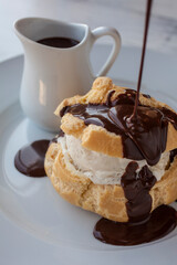 Cream puff with ice cream and chocolate sauce