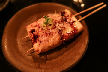 close up of Japanese deep fried tofu bean curd skewer with sauce and spring onion