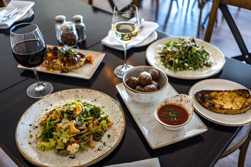 Table full of food including wine and pasta 