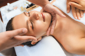 Caucasian woman enjoying relaxing anti-stress head massage and pampering facial beauty skin recreation leisure in dayspa modern light ambient at luxury resort or hotel spa salon. Quiescent