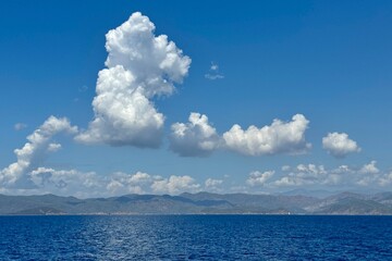 A abstract formation of white clouds on the  blue sky above water in Fethiye Bay in Turkey 
